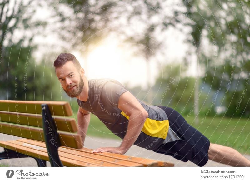 Junger Mann, der StoßUPS in einem Park tut Lifestyle Körper Gesicht Sport maskulin Erwachsene 1 Mensch 18-30 Jahre Jugendliche Vollbart Fitness Aktion sportlich