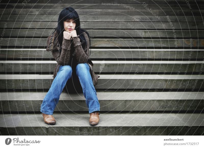einsame Frau sitzt auf den Stufen Lifestyle Mensch Junge Frau Jugendliche Erwachsene 1 18-30 Jahre Treppe Jeanshose schwarzhaarig langhaarig Stein Denken sitzen