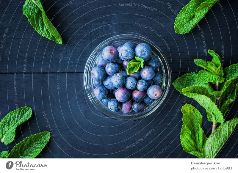 Blaubeere mit Minze in einer Glasschüssel Lebensmittel Ernährung Vegetarische Ernährung Tisch Holz frisch hell blau grün Farbe Hintergrund Beeren Blaubeeren