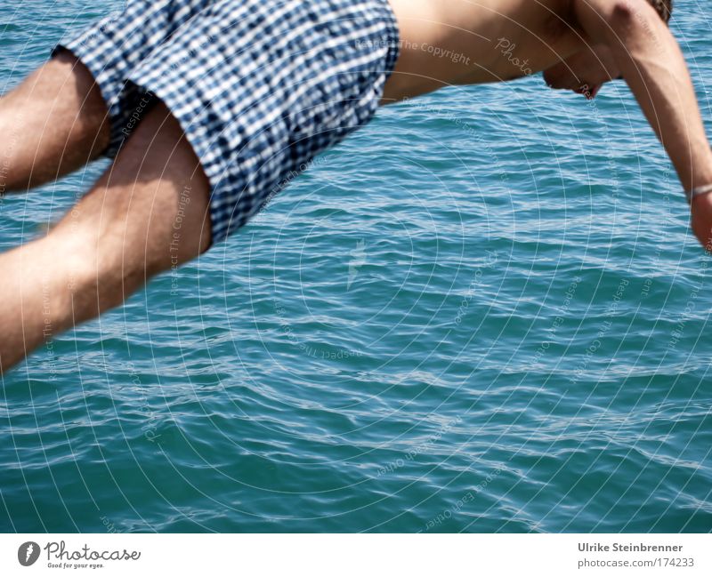 Junger Mann in Badehose beim Sprung in den See Farbfoto Außenaufnahme Textfreiraum unten Tag Sonnenlicht Freude Wellness Sommer Wellen Mensch maskulin