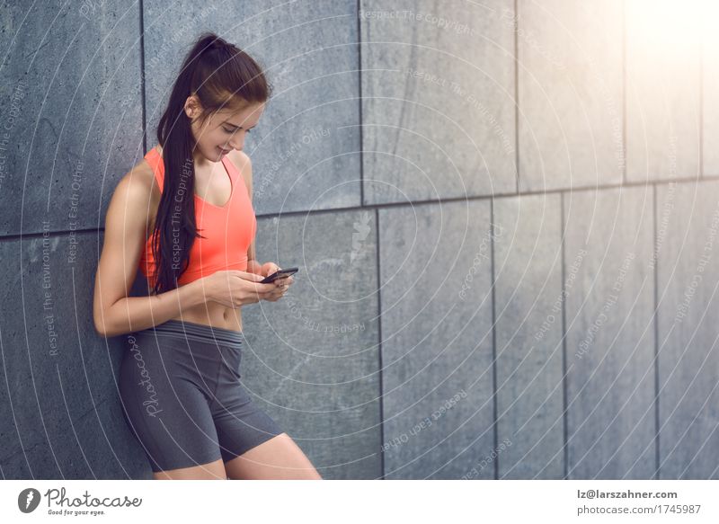 Sportliche junge Frau mit Smartphone Gesicht Sommer Telefon PDA feminin Junge Frau Jugendliche Erwachsene 1 Mensch 18-30 Jahre Wärme brünett Fitness Lächeln