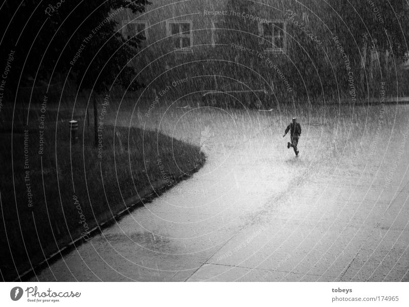 Die Flucht Mensch maskulin laufen rennen Regen Gewitter Sturm Hagel Einsamkeit nass feucht kalt trocken Schwarzweißfoto Außenaufnahme Kontrast