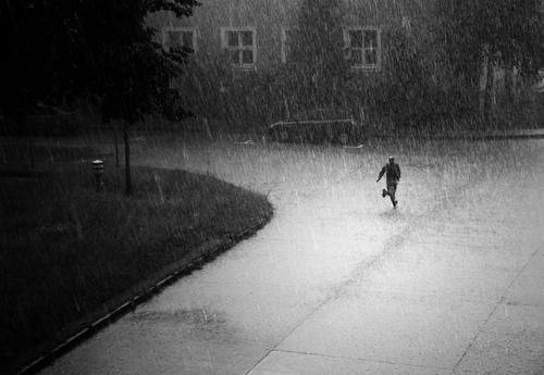 Die Flucht Mensch maskulin laufen rennen Regen Gewitter Sturm Hagel Einsamkeit nass feucht kalt trocken Schwarzweißfoto Außenaufnahme Kontrast