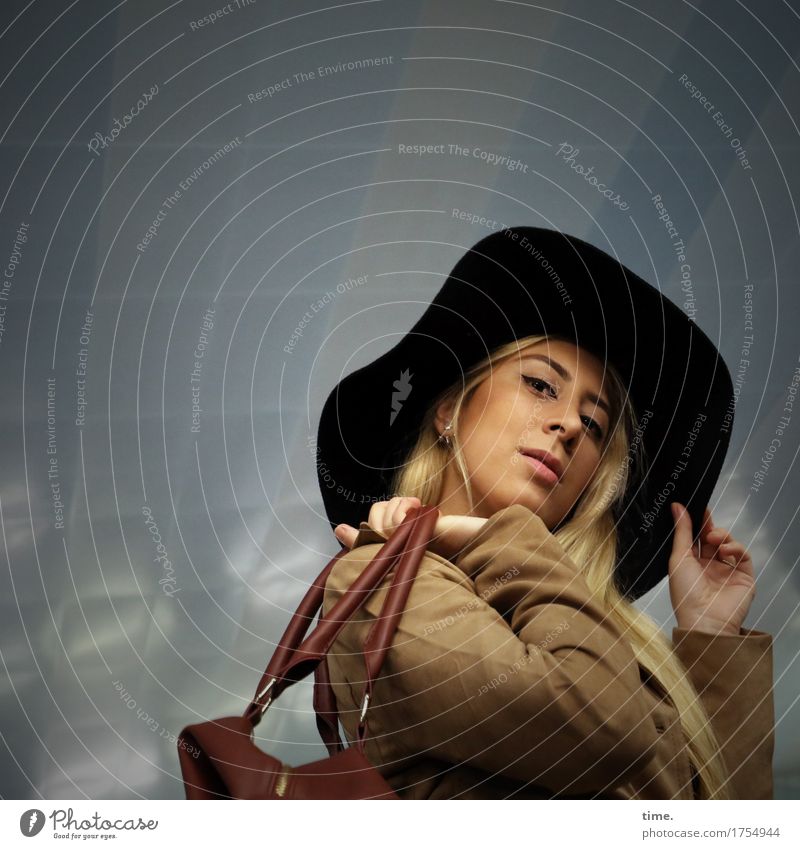 . feminin 1 Mensch Mauer Wand Mantel Tasche Hut blond langhaarig beobachten Blick ästhetisch Freundlichkeit trendy schön Zufriedenheit selbstbewußt