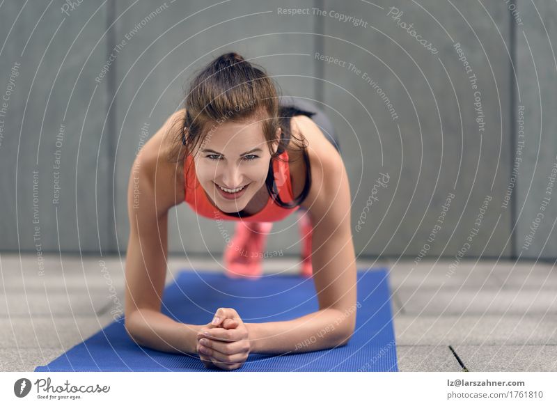Geeignete junge Frau, die Planken tut Lifestyle Glück Körper Gesicht Sport Erwachsene 1 Mensch 18-30 Jahre Jugendliche brünett Fitness Lächeln Athlet sportlich