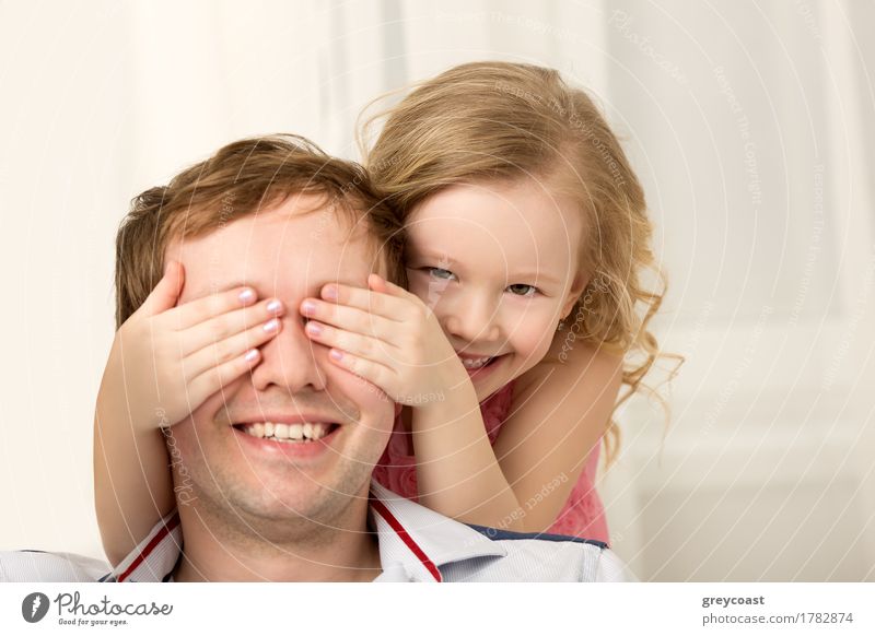 Vater und Tochter spielen zu Hause. Kleines Mädchen schließt Väter Augen mit den Händen und lachen. Familie Spaß zusammen Freude Glück Spielen Kind Mensch