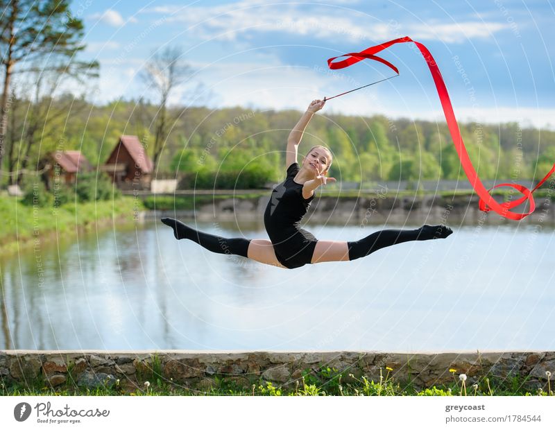Junge rhythmische Gymnastin beim Spagatsprung während der Bandübungen. Körper Sommer Sport Mensch feminin Mädchen Jugendliche 1 13-18 Jahre Eisenbahn blond