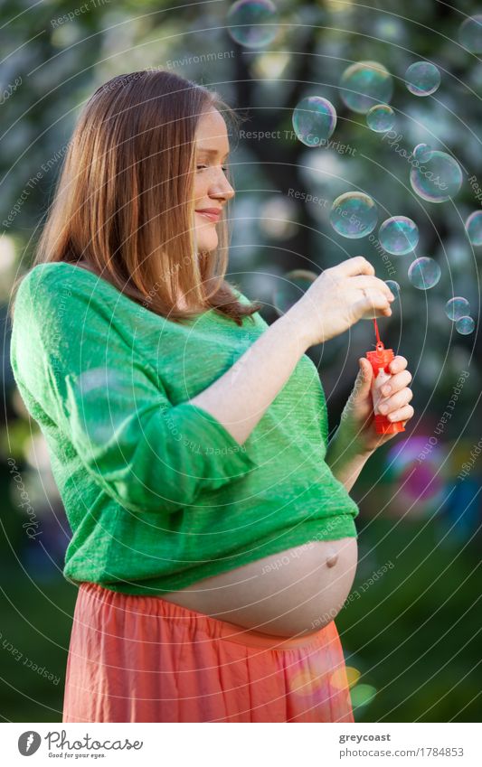 Lächelnde schwangere Frau genießt die Zeit mit Blasen im Freien. Glückliche und gesunde Schwangerschaft Freude Erholung Freizeit & Hobby Sommer Mensch Mädchen