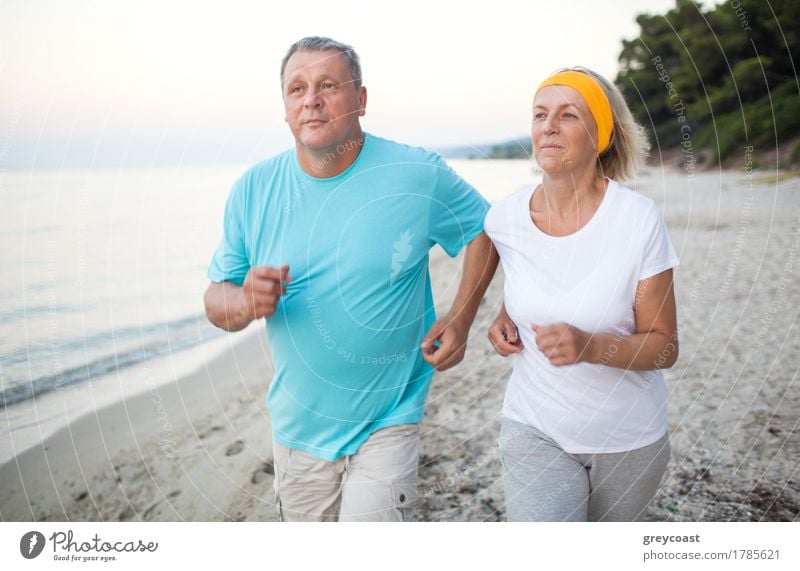 Älterer Mann und Frau, die einen Lauf entlang der Küste haben. Szene mit Meer, Sand und Bäumen. Gesunde und aktive Lebensweise Lifestyle Freizeit & Hobby