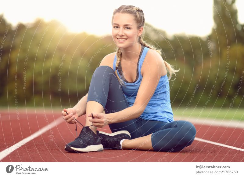 Sportliche junge Frau, die ihre Spitzee bindet Lifestyle schön Sommer Sonne Erwachsene 1 Mensch 18-30 Jahre Jugendliche Wärme Schuhe blond Fitness Lächeln