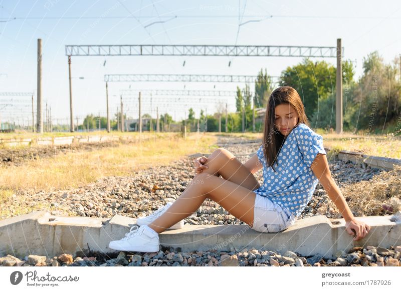 Brunette Mädchen Teenager sitzt auf dem Beton der unvollendeten Bahnstrecke außerhalb der Stadt Sommer Jugendliche 1 Mensch 13-18 Jahre Landschaft Kleinstadt