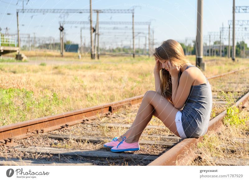 Trauriges Mädchen Teenager sitzt auf rostigen Eisenbahnschienen außerhalb der Stadt. Flucht, um allein zu sein Sommer Frau Erwachsene Jugendliche Landschaft