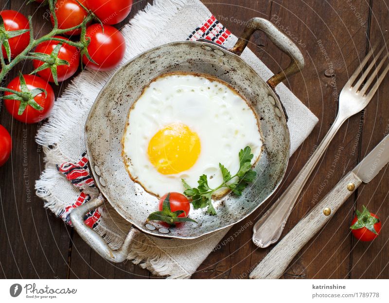 Spiegelei mit Tomaten und Kräutern Gemüse Essen Frühstück Abendessen Pfanne Tisch Holz frisch gelb grün rot Cholesterin Eierschale braten Mahlzeit Protein