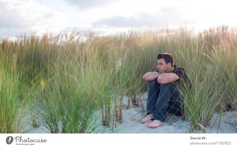 Ruhe und Abstand in den Dünen an der Küste genießen. Mann alleine Einsamkeit Kurort windig Wind Sand sitzen