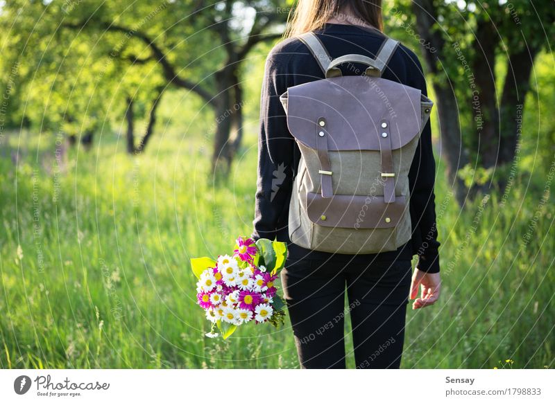 Frau, die in der Hand mit Rucksack und Blumen wandert Glück schön Ausflug Sommer Sonne wandern Schule Mensch Mädchen Erwachsene Jugendliche Natur Park Straße