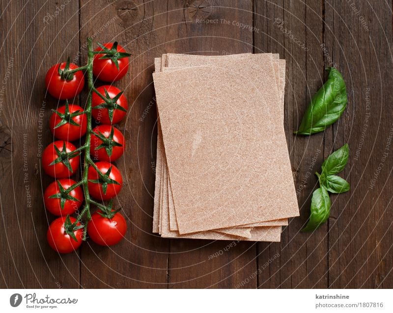 Vollkorn Lasagne Blätter, Tomaten und Basilikum Gemüse Teigwaren Backwaren Kräuter & Gewürze Vegetarische Ernährung Diät Italienische Küche Tisch Blatt dunkel