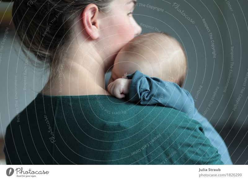 Junge Mutter mit schlafenden Baby auf dem Arm feminin Frau Erwachsene 2 Mensch 0-12 Monate 30-45 Jahre brünett kuschlig Wärme blau grün türkis Vertrauen
