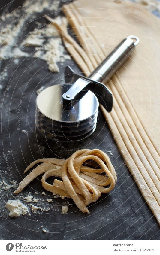 Making hausgemachte Taglatelle mit einer Pasta Rollschneider Teigwaren Backwaren Ernährung Italienische Küche Tisch Werkzeug machen dunkel frisch Tradition