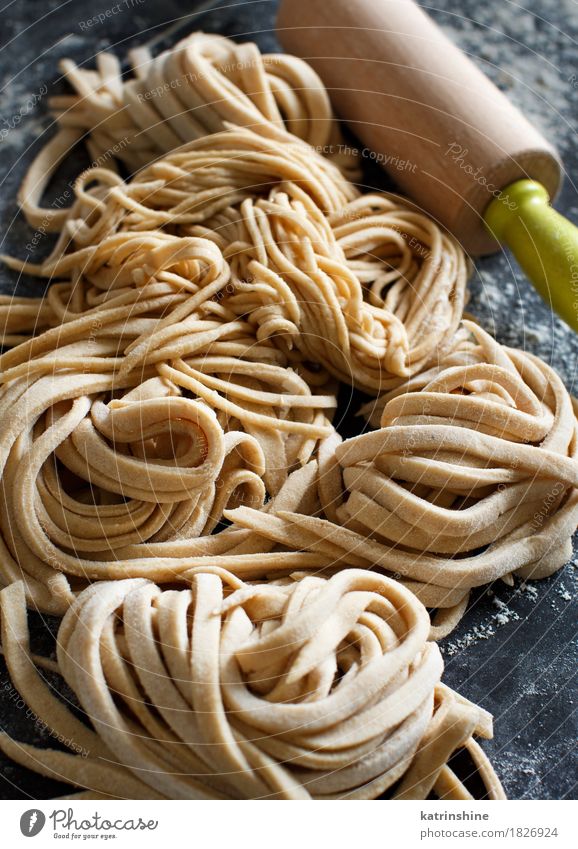 Frische hausgemachte Pasta und Nudelholz Teigwaren Backwaren Vegetarische Ernährung Italienische Küche dunkel frisch gelb Kohlenhydrat Essen zubereiten Mehl