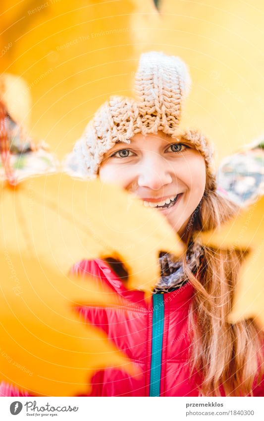 Lächelndes Mädchen, das hinter den verschwommenen gelben Herbstblättern steht Glück schön Garten Jugendliche Gesicht 1 Mensch 8-13 Jahre Kind Kindheit Natur