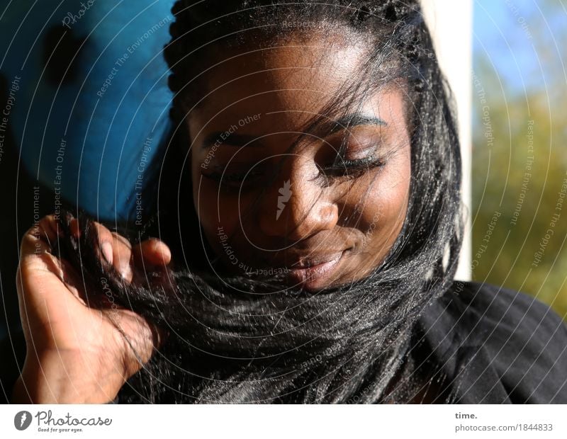 . feminin 1 Mensch Schönes Wetter Mauer Wand Jacke schwarzhaarig langhaarig Afro-Look berühren Erholung festhalten Lächeln träumen schön Zufriedenheit
