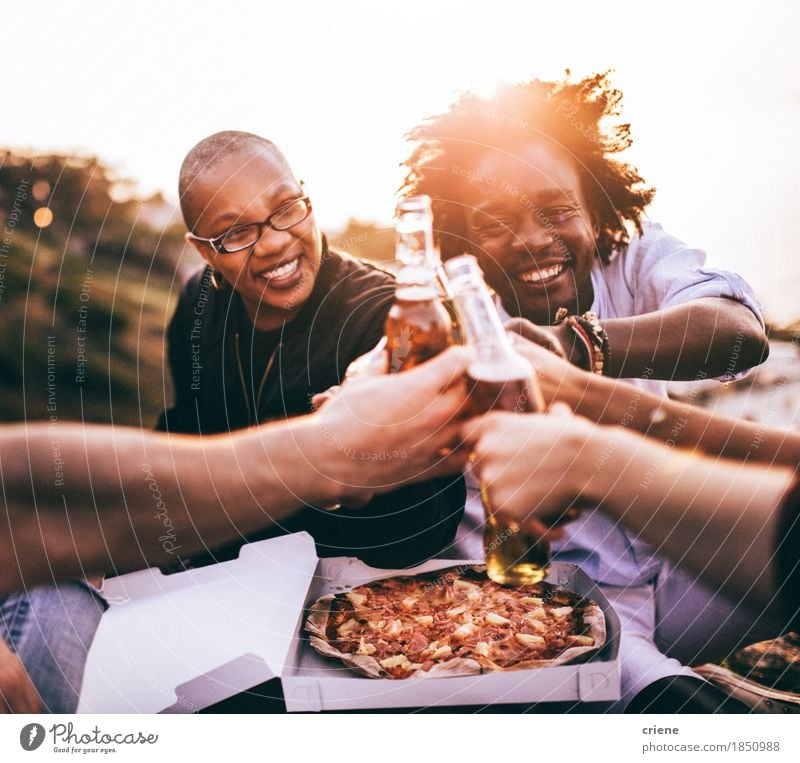Multi-ethnische Gruppe Freunde, die Getränke und Pizza genießen Lebensmittel Essen Mittagessen Abendessen trinken Erfrischungsgetränk Alkohol Bier Flasche