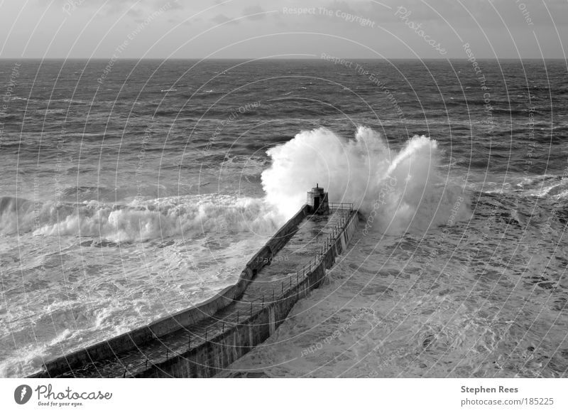 Große atlantische Welle bricht am Portreath Pier aus. Meer Wellen Winter Natur Landschaft Himmel Horizont Wetter Küste schwarz weiß Atlantik Unwetter winken