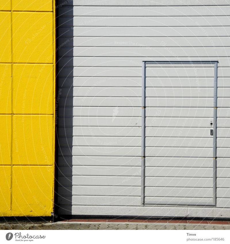 Noteingang Industrieanlage Gebäude Mauer Wand Fassade Tür gelb grau gestreift kariert Eingang Eingangstür Ausgang Rolltor Ladezone Hintereingang Gebäudeteil