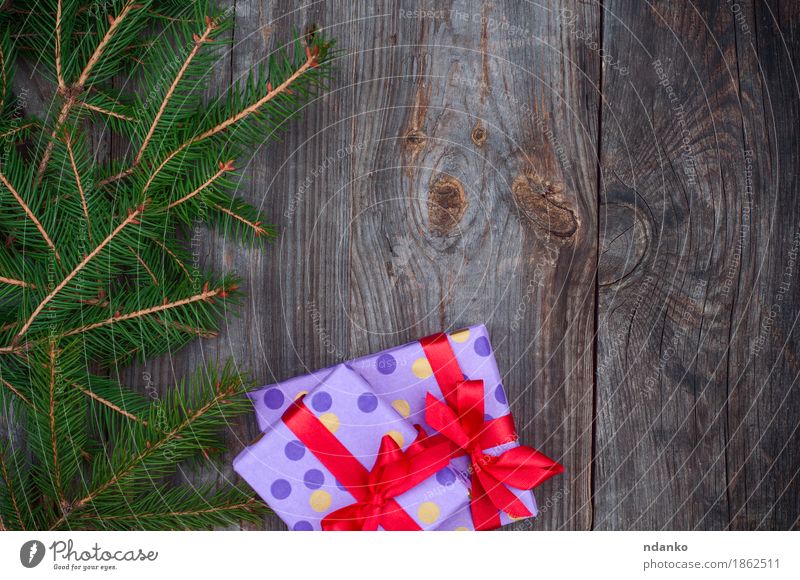 Grauer hölzerner festlicher Hintergrund mit Niederlassungen der Fichte Winter Dekoration & Verzierung Silvester u. Neujahr Baum Holz Schnur grau grün rot