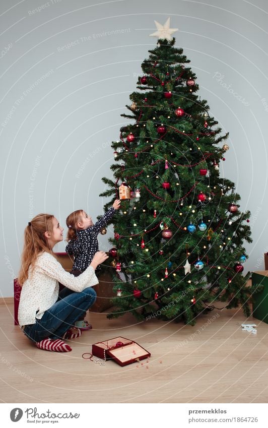 Junges Mädchen und ihre kleine Schwester, die Weihnachtsbaum verziert Lifestyle Freude Dekoration & Verzierung Feste & Feiern Weihnachten & Advent Kind