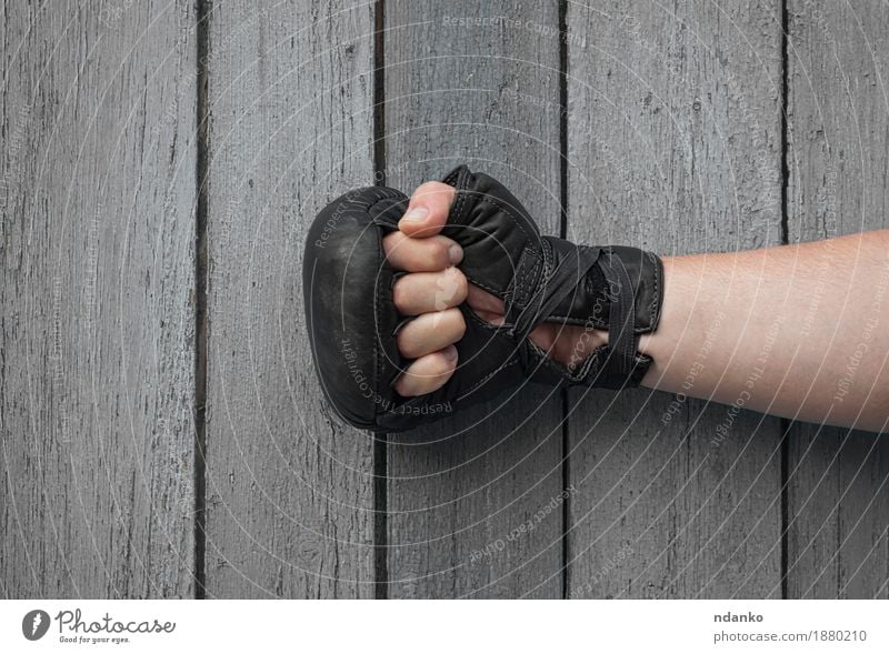 Handmann in den schwarzen Lederhandschuhen für thailändisches Verpacken Sport Erfolg Verlierer Fußball maskulin Haut Finger Handschuhe Holz alt retro grau