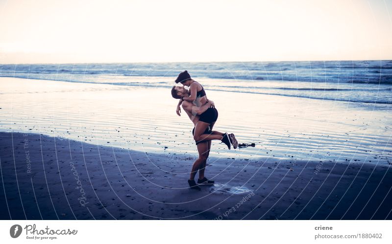 Junge erwachsene Paare, die auf Strand nachdem laufendem Training küssen Lifestyle Freude Körper sportlich Fitness Freizeit & Hobby Wellen Sport Junge Frau