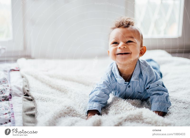 Nettes entzückendes lächelndes Kleinkind beim auf Bett zu Hause legen Lifestyle Freude Körper Gesicht Kindererziehung Mensch Baby Kindheit 0-12 Monate Lächeln