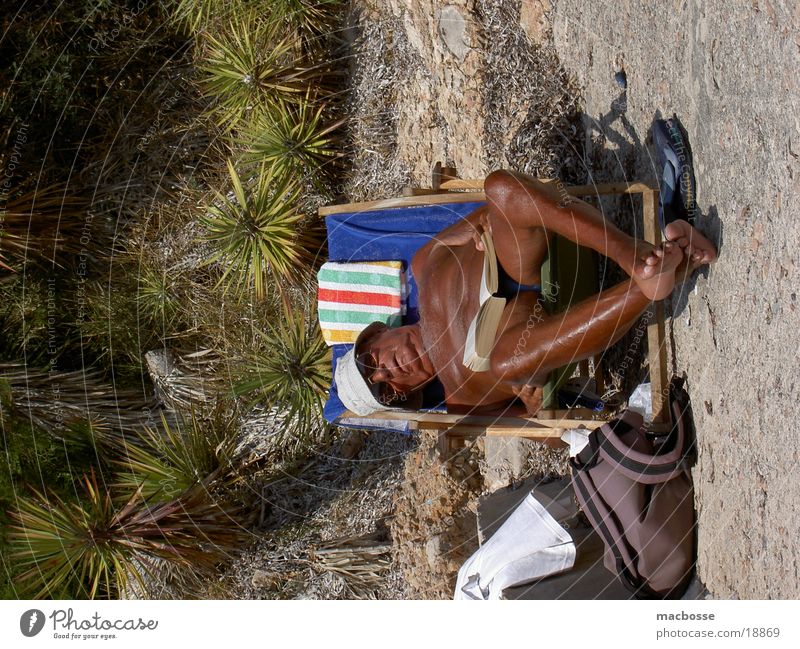 Alter Mann im Liegestuhl Spanien Süden Senior Licht Stil Platz Freiraum Vorgesetzter nackt Sonnenbrand Sonnenbad Verlauf braun Mütze Handtuch Strand Meer