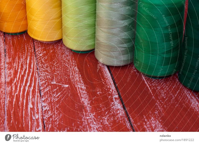 Einige farbige Garnrollen zum Nähen Basteln Handarbeit Stickereien Nähgarn Tisch Industrie Platz mehrfarbig gelb grau grün orange rot Farbe Garnspulen Rolle
