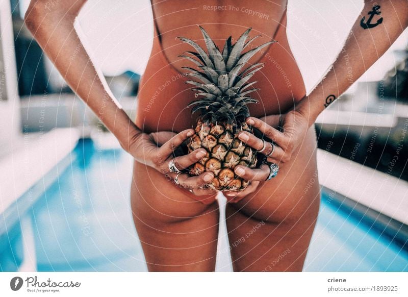 Nahaufnahme von den Frauen, die hinter ihr zurück Ananas halten Frucht Lifestyle Schwimmbad Schwimmen & Baden Sommer Sonne Sonnenbad Traumhaus Garten feminin