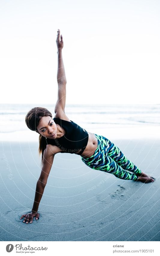 Geeignete junge erwachsene afrikanische Frauen, die Yoga auf Strand tun Lifestyle Körper Gesundheitswesen sportlich Fitness Leben Meer Wellen Sport feminin