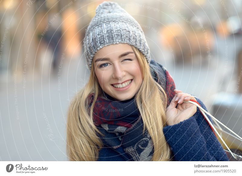 Herrliche junge Frau, die heraus kauft und blinzelt kaufen Glück schön Gesicht Winter Erwachsene 1 Mensch 18-30 Jahre Jugendliche Fußgänger Straße Mode Schal
