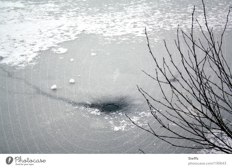 Eisloh in einem gefrorenen See Eisloch nordische Kälte heimisch eisbedeckt winterliche Stille Winterstille Wintereinbruch Kälteeinbruch Wintermelancholie grau