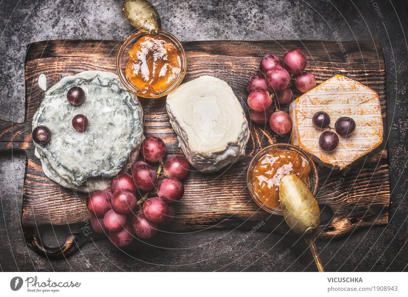 Rustikale Käseplatte mit verschiedenen Käse Lebensmittel Frucht Ernährung Getränk Stil Design Restaurant gelb Brie Feinschmecker Snack altehrwürdig