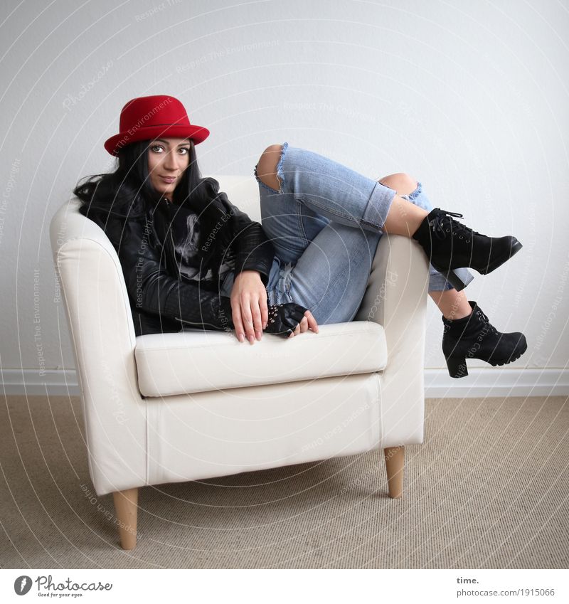 Nastya Sessel Raum feminin Frau Erwachsene Jeanshose Jacke Stiefel Hut schwarzhaarig langhaarig beobachten Erholung Lächeln Blick sitzen warten schön