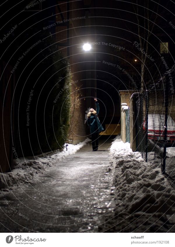 Erleuchtung II Mensch 1 Nachthimmel Mond Winter Eis Frost Schnee Kleinstadt Menschenleer Fassade Fußgänger Wege & Pfade Mantel berühren gehen leuchten stehen