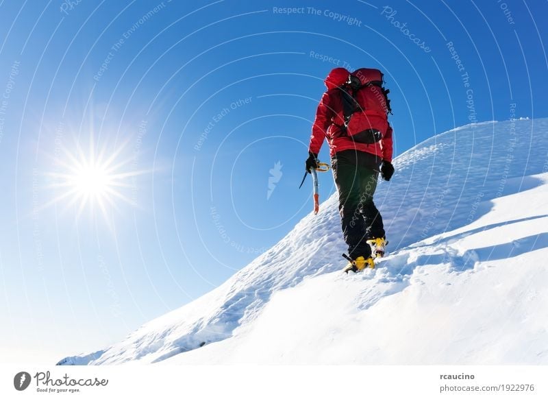 Kletterer erreicht die Spitze eines schneebedeckten Gipfels Ferien & Urlaub & Reisen Abenteuer Expedition Winter Schnee Berge u. Gebirge wandern Sport Klettern