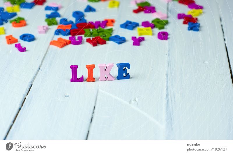 weißer hölzerner Hintergrund mit dem Wort mögen Schule Spielzeug Holz genießen klein blau mehrfarbig rosa Gefühle Freude Idee bitte Berufung ausgefallen holen