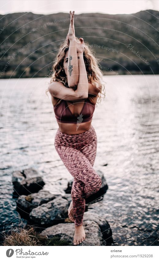 Junger weiblicher Erwachsener, der draußen Yogahaltung an einem See tut Lifestyle Meditation Freizeit & Hobby Sport Fitness Sport-Training Mensch feminin