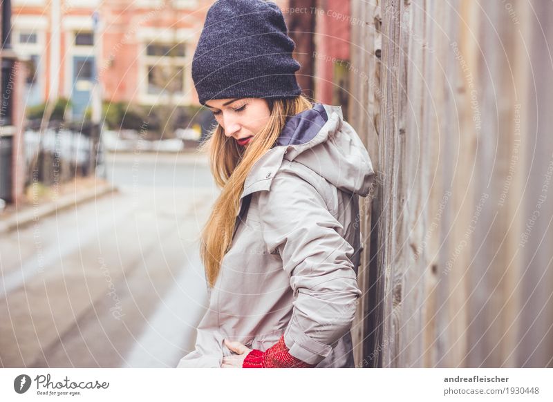 Junge Frau wartet am Holzzaun auf ihren Freund Lifestyle Ausflug Städtereise feminin Jugendliche 1 Mensch 18-30 Jahre Erwachsene Pullover Jacke Mütze blond