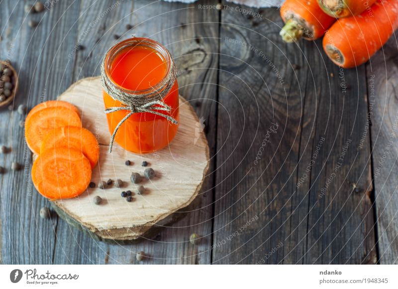 Frischer Karottensaft in einem Glasgefäß auf einer Holzoberfläche Gemüse Kräuter & Gewürze Ernährung Vegetarische Ernährung Diät Getränk Saft Flasche