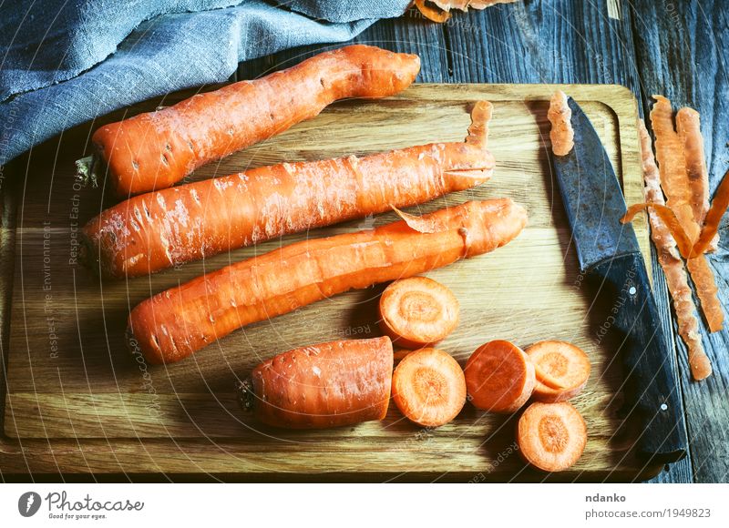 frische lange Karotte auf einem Schneidebrett Gemüse Ernährung Essen Vegetarische Ernährung Diät Tisch Natur Holz natürlich oben retro orange Tischwäsche