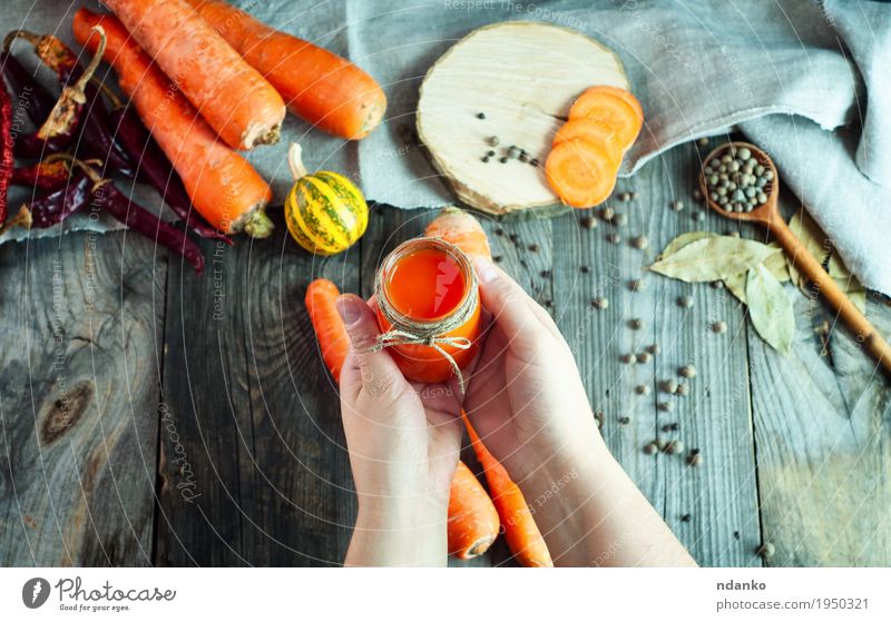 Glas frischer Karottensaft in der weiblichen Hand Gemüse Frucht Kräuter & Gewürze Saft Flasche Löffel Körper Haut Gesundheitswesen Tisch Frau Erwachsene Arme 1
