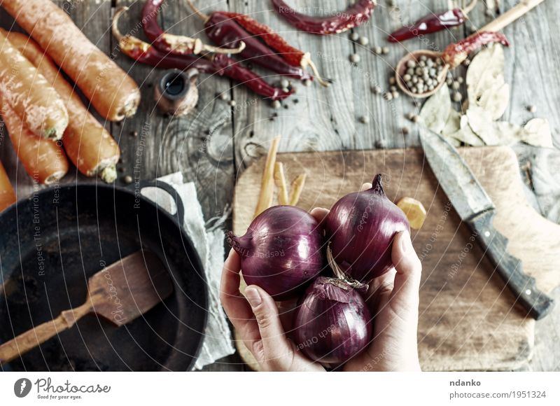 drei große rote Zwiebeln in weiblichen Händen Lebensmittel Gemüse Kräuter & Gewürze Essen Vegetarische Ernährung Pfanne Messer Löffel Tisch Koch Küche Frau